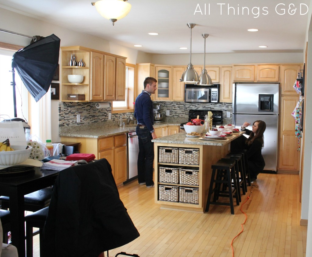 Setting up a lighting unit on the floor to illuminate the back corner of the kitchen.