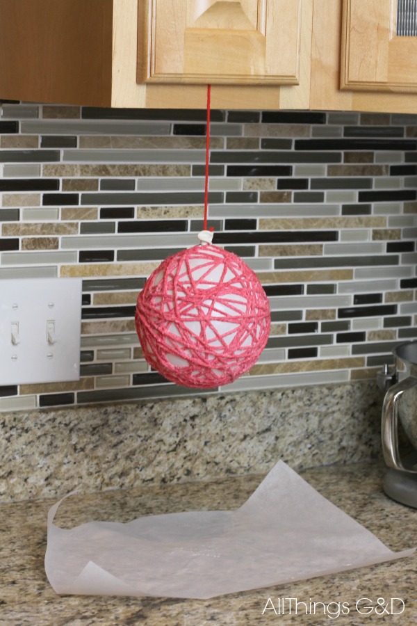 All you need is yarn, glue, and balloons to make these eye-catching DIY Yarn Ball Ornaments! Post includes a side-by-side comparison of best glues to use. | www.allthingsgd.com