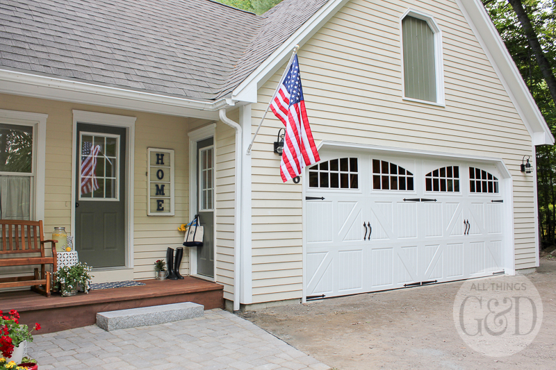 Lowe's Front Yard Makeover in Portland, Maine featuring a new paver patio, outdoor decorations, Pella carriage style garage door, and trim-free landscape edging.
