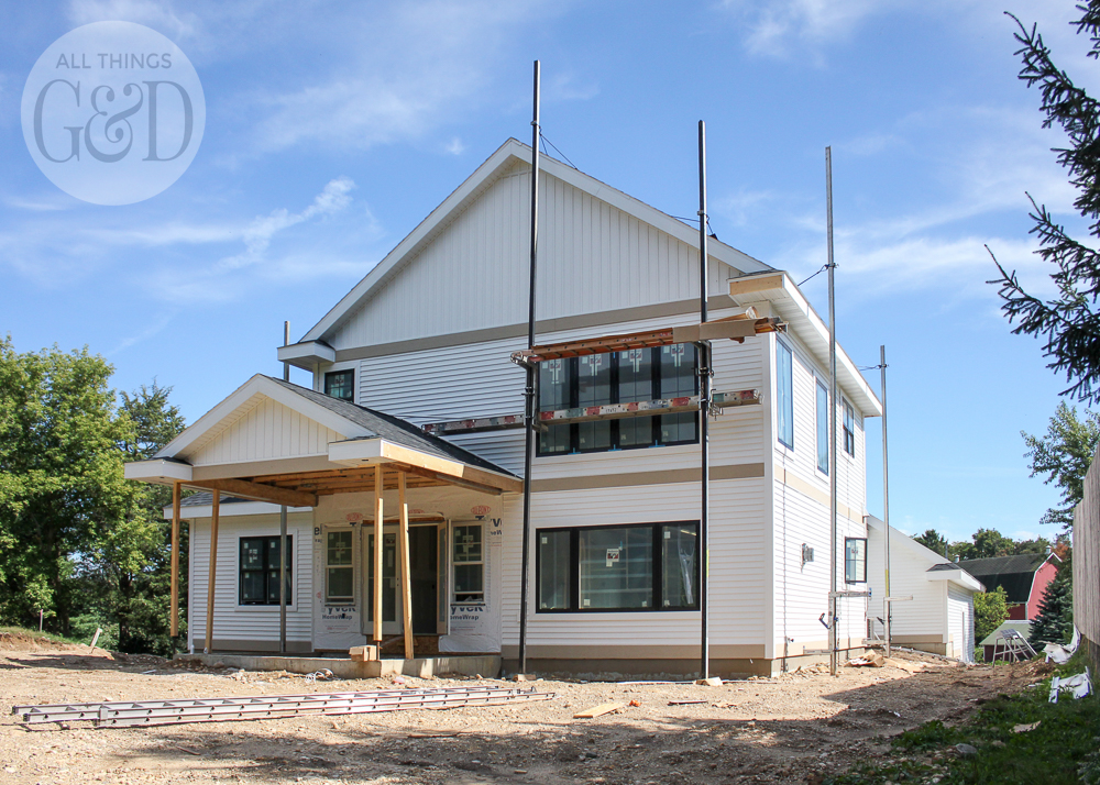 New home construction: white siding and natural stone. | All Things G&D #ATGDdreamhome #newhomeconstruction #customhome #customhomeconstruction #whitesiding #blackwindows #naturalstone #chiltonivory
