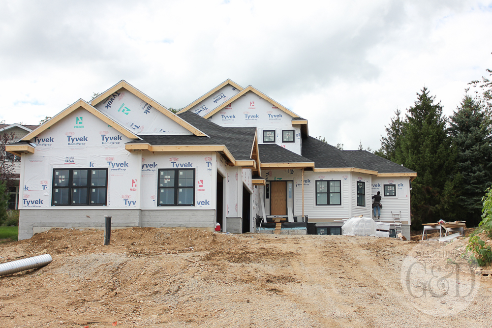 New home construction: white siding and natural stone. | All Things G&D #ATGDdreamhome #newhomeconstruction #customhome #customhomeconstruction #whitesiding #blackwindows #naturalstone #chiltonivory