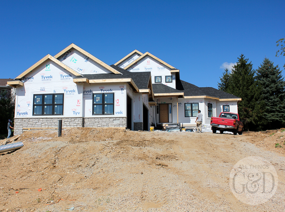 New home construction: white siding and natural stone. | All Things G&D #ATGDdreamhome #newhomeconstruction #customhome #customhomeconstruction #whitesiding #blackwindows #naturalstone #chiltonivory